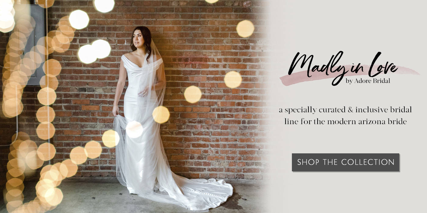 Bride wearing simple gown standing in front of a brick wall